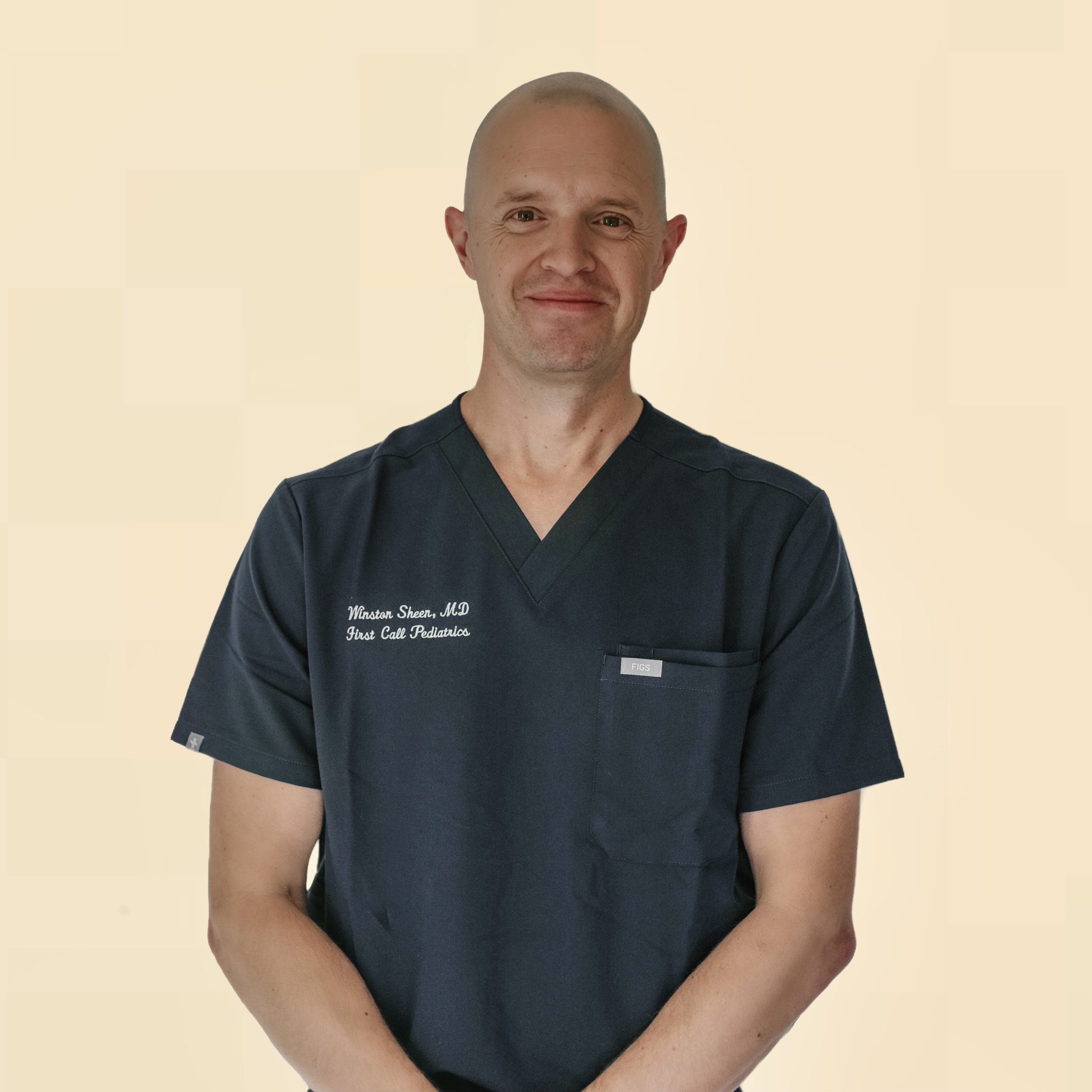 Male Pediatric Doctor in First Call Pediatric Scrubs, smiling, in Jacksonville, Fl.