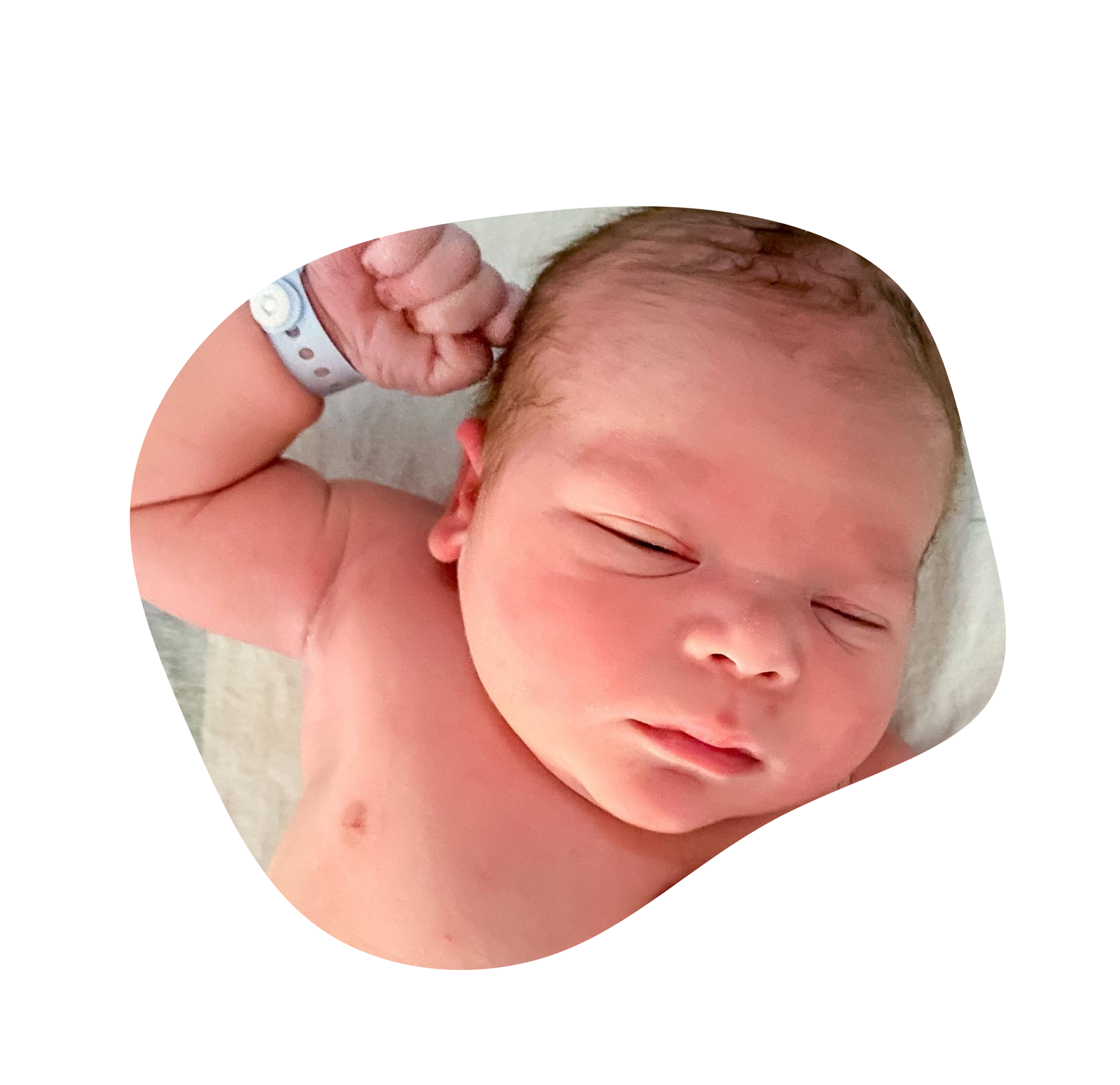 Newborn baby stretching out right arm, while laying on hospital blanket, at UF North Hospital, Jacksonville, FL