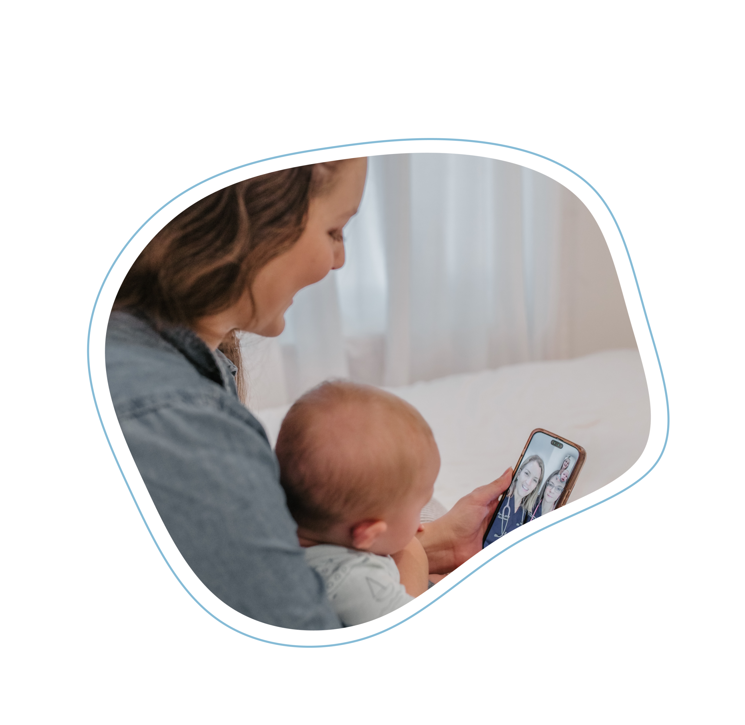 Mother, smiling, holding an infant boy in lap, looking at telehealth appointment on cell phone, with screen showing two pediatric care providers, who are wearing First Call Pediatrics scrubs, smiling and have stethoscopes around neck in-home at Jacksonville, Fl.