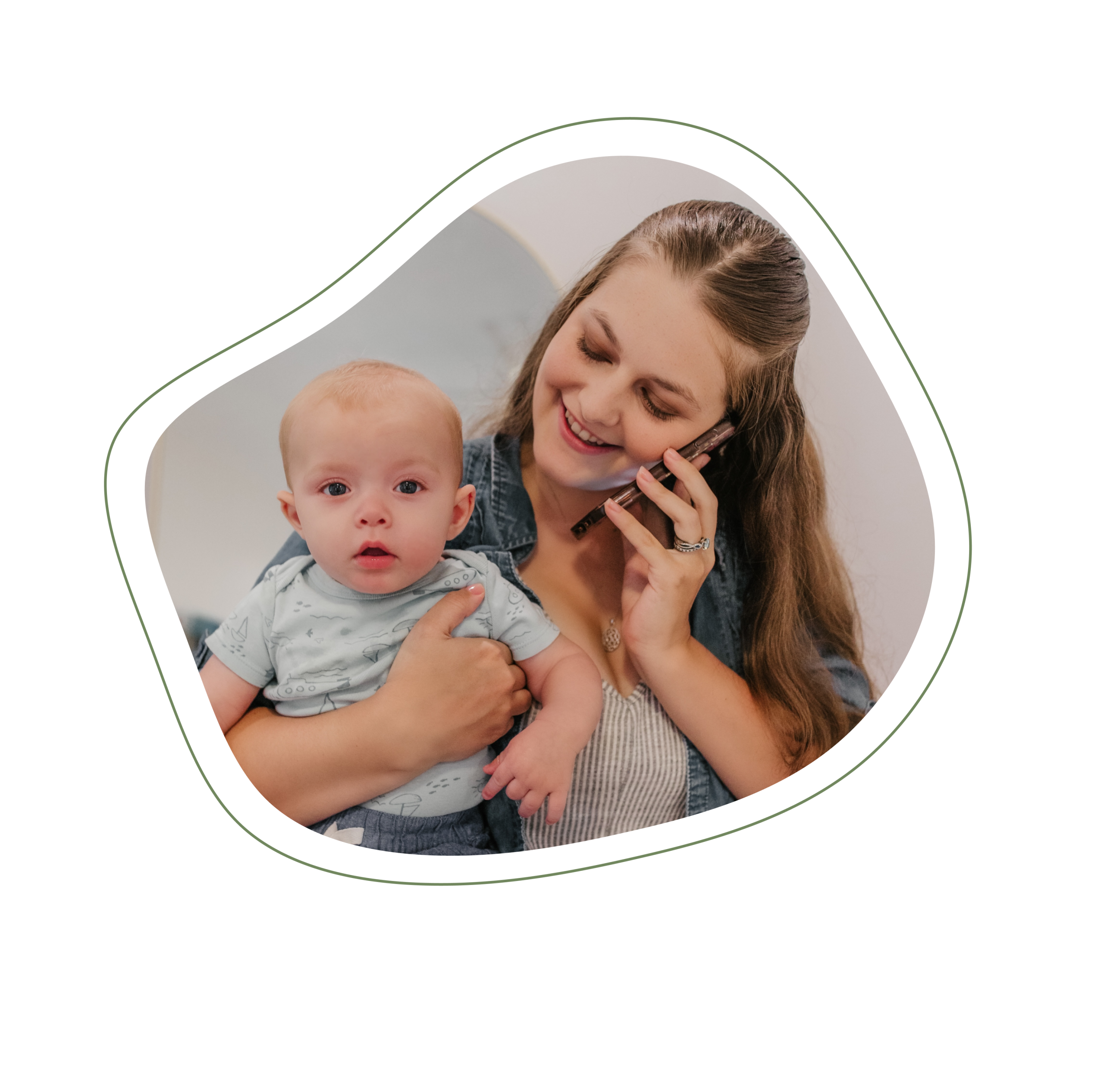 Mother is standing, holding phone in left hand, pressed to ear, smiling down at baby being held in her right hand, while baby looks straight ahead in-home in Jacksonville, Fl.