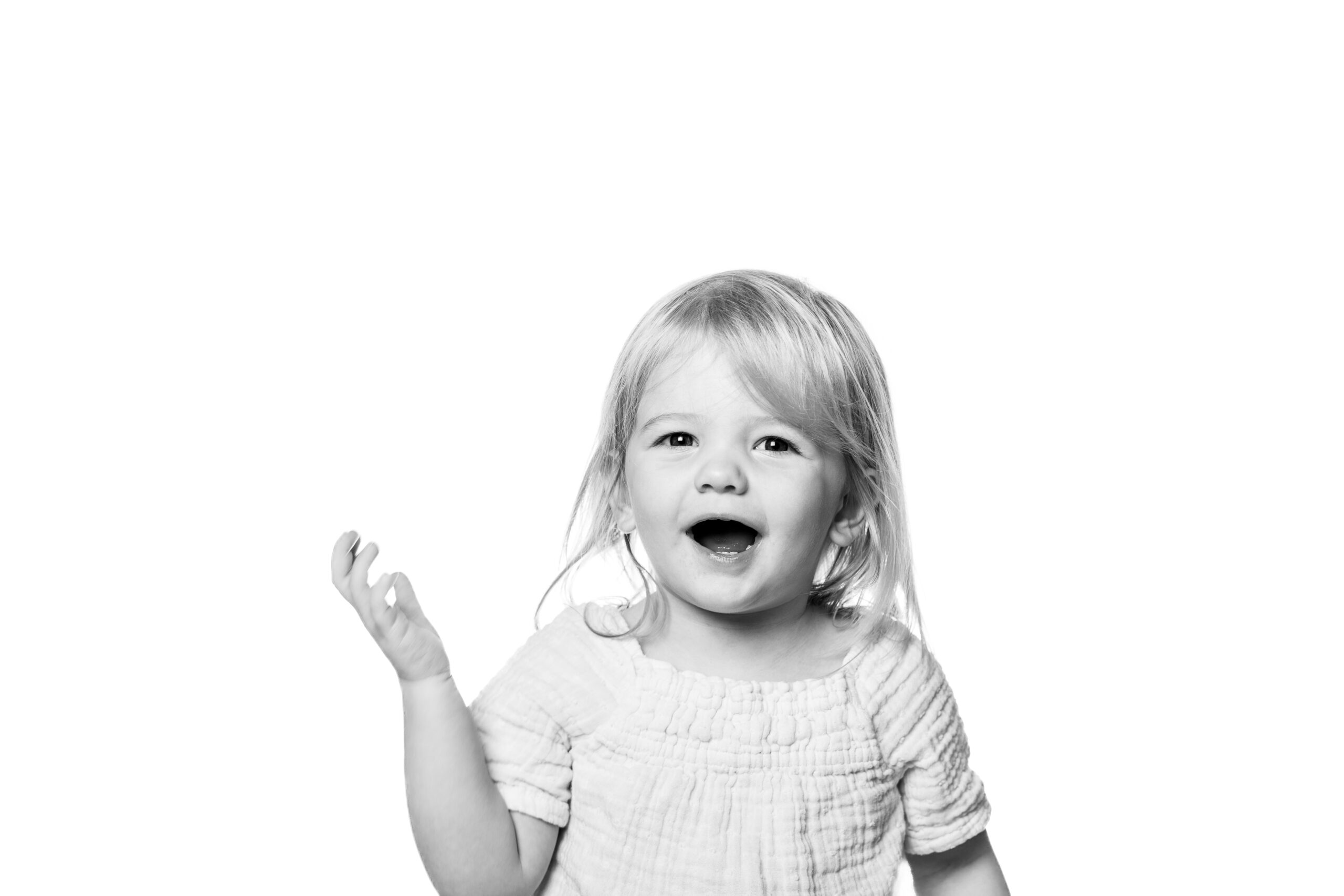 61_toddler laughing, in white dress, with white background, in Jacksonville, FL
